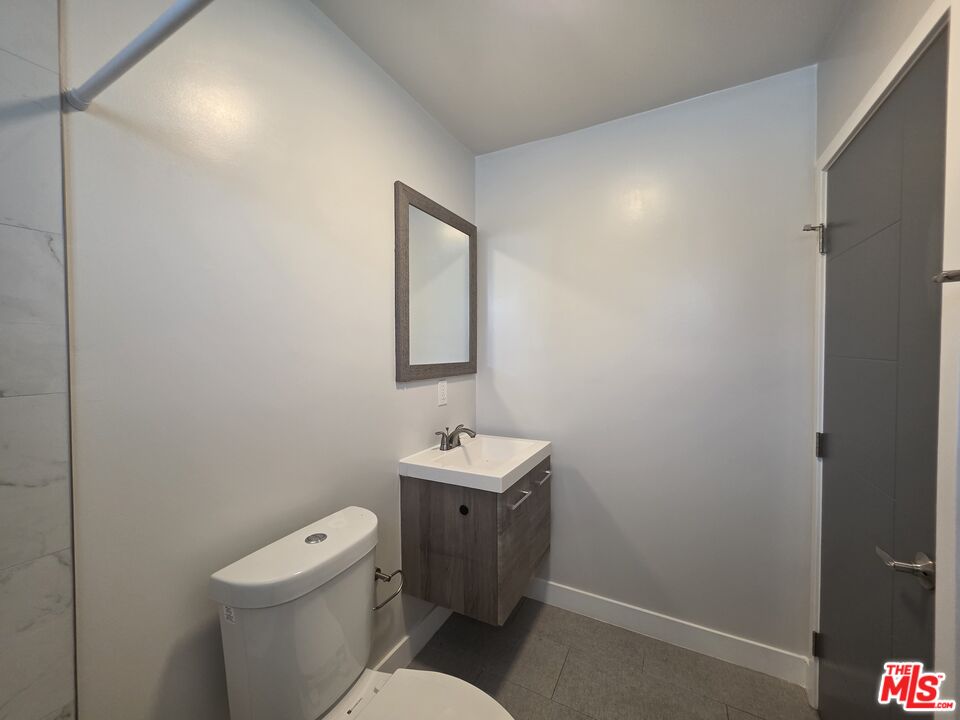 1505 South Cochran Avenue, Unit 4 Los Angeles, CA 90019 - Photo 30 of 45 a bathroom with a toilet a sink and mirror