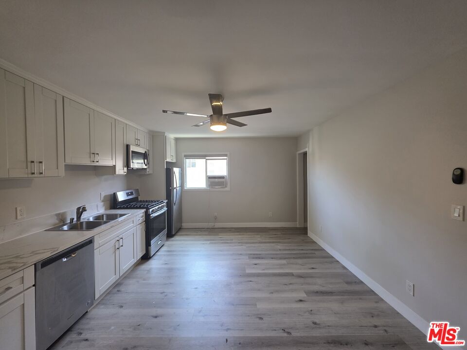 1505 South Cochran Avenue, Unit 4 Los Angeles, CA 90019 - Photo 4 of 45 a kitchen with granite countertop a stove and a refrigerator