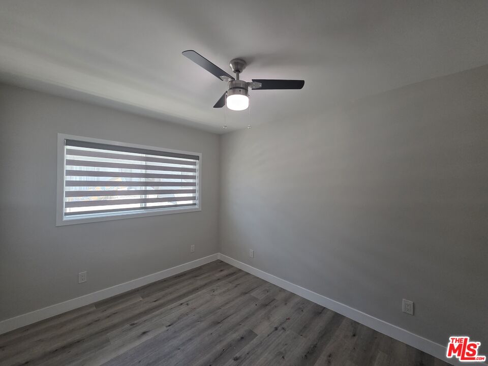 1505 South Cochran Avenue, Unit 4 Los Angeles, CA 90019 - Photo 6 of 45 a view of an empty room with wooden floor and a window
