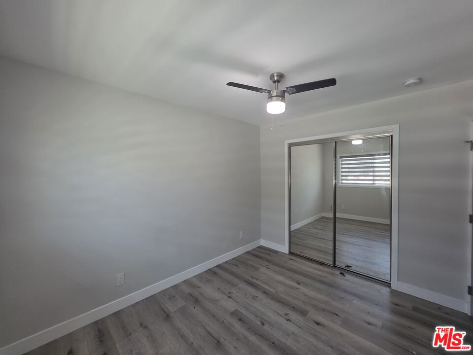 1505 South Cochran Avenue, Unit 4 Los Angeles, CA 90019 - Photo 8 of 45 an empty room with wooden floor and ceiling fan