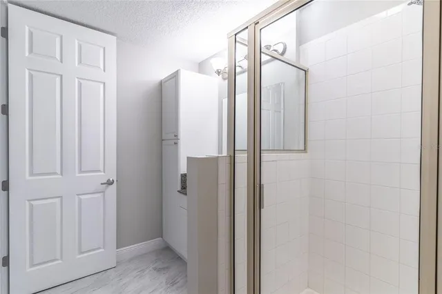 a bathroom with a glass shower door and a shower