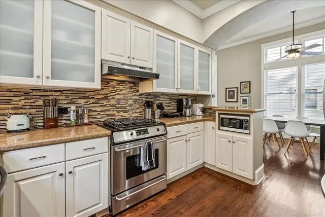 a kitchen with granite countertop cabinets stainless steel appliances and wooden floor