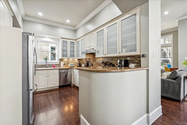 a kitchen with a refrigerator a sink and a stove top oven