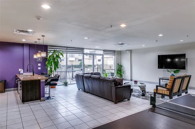a living room with furniture a flat screen tv and floor to ceiling window