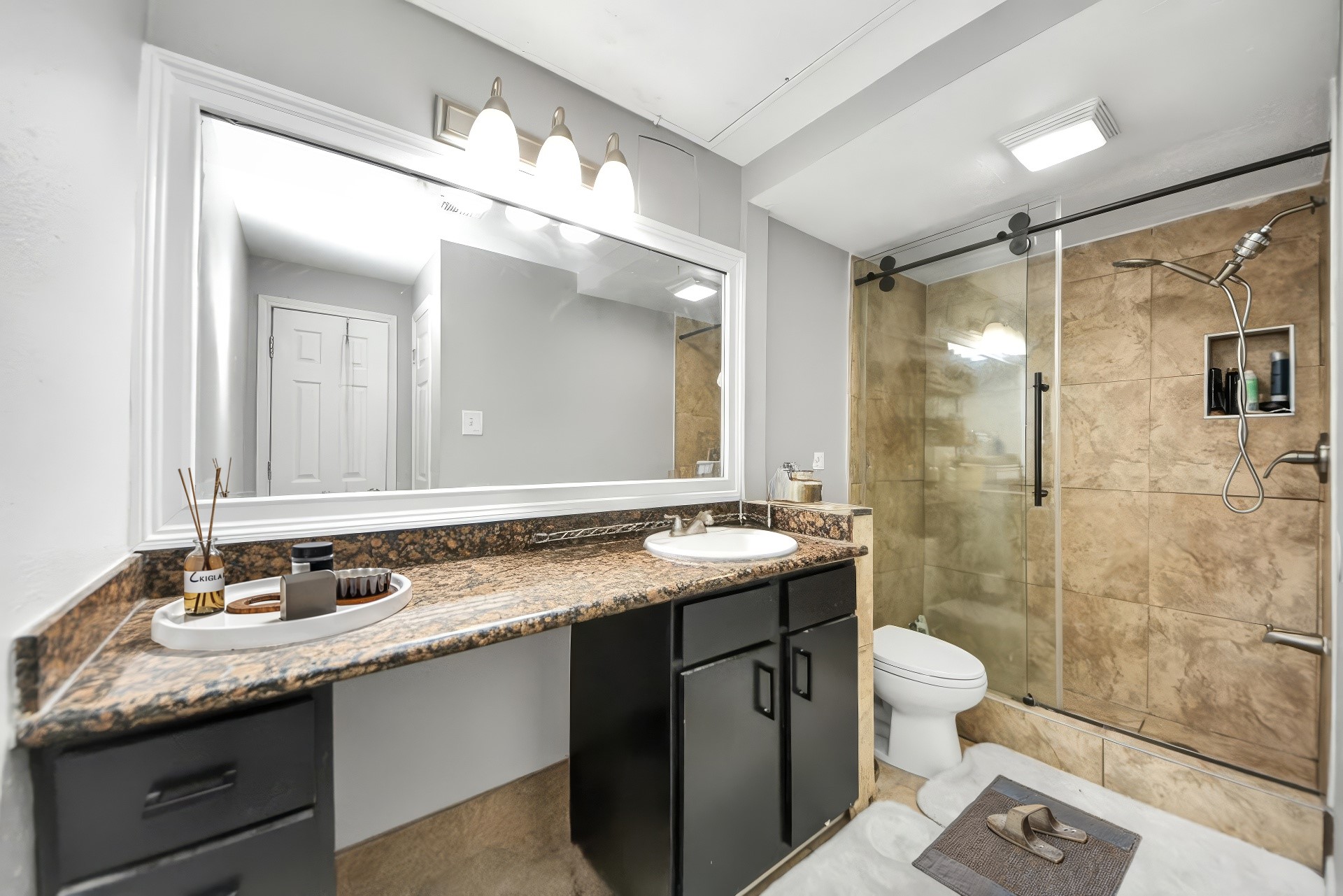 2100 Tanglewilde Street, Unit 312 Houston, TX 77063 - Photo 7 of 11 a bathroom with a granite countertop sink mirror toilet and shower