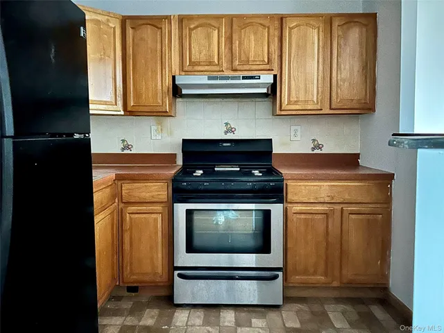a kitchen with granite countertop a stove top oven microwave and cabinets