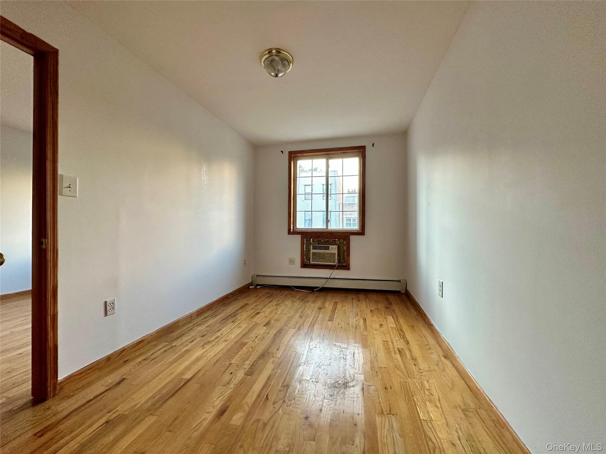 22 Jefferson Street, Unit 3 Brooklyn, NY 11206 - Photo 7 of 12 an empty room with wooden floor and windows
