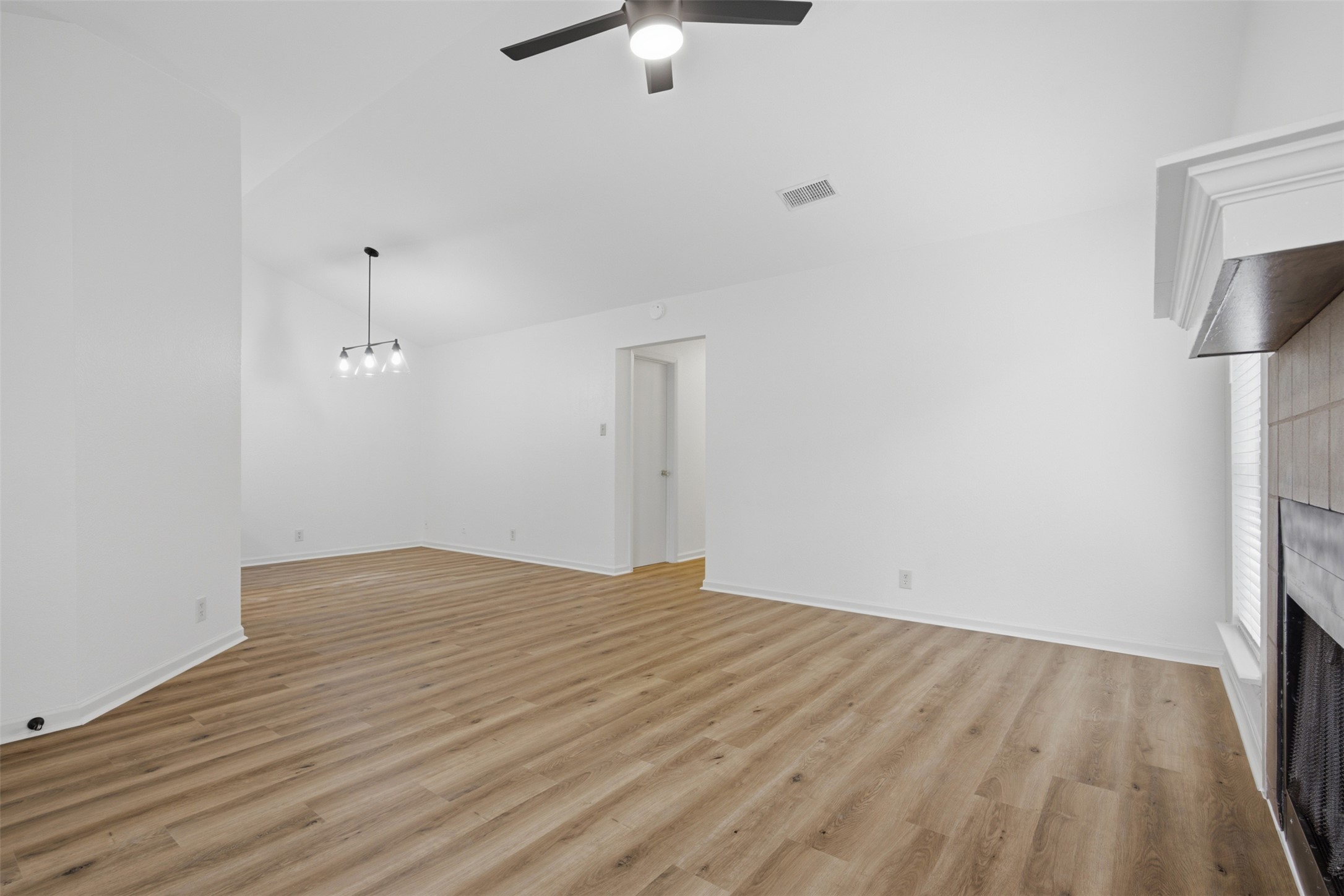 11611 Rustic Rock Drive, Unit B Austin, TX 78750 - Photo 5 of 30 A living space offers fresh paint, light wood-look flooring, a modern fan