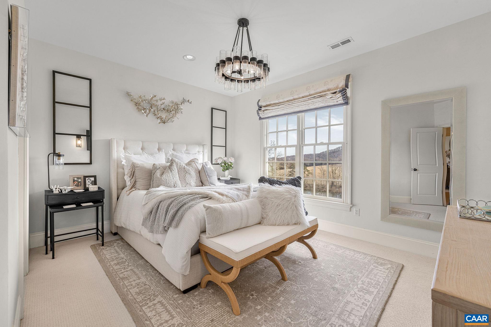 0 Ragged Mountain Drive Charlottesville, VA 22903 - Photo 50 of 70 a spacious bedroom with a bed a chandelier and a window