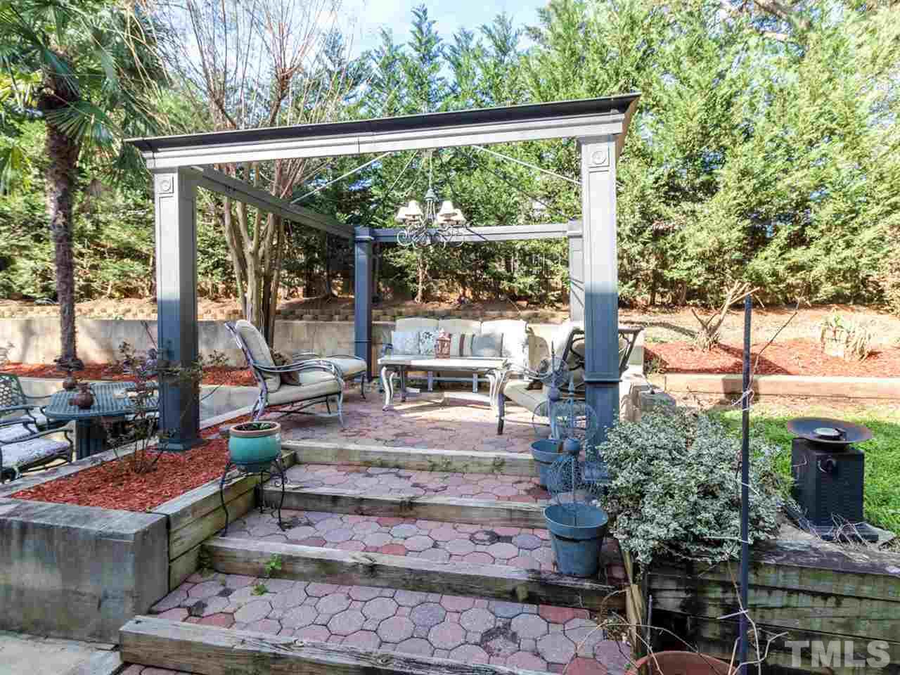 2500 Bulmer Terrace Raleigh, NC 27615 - Photo 25 of 25 a view of a patio with table and chairs potted plants and large tree
