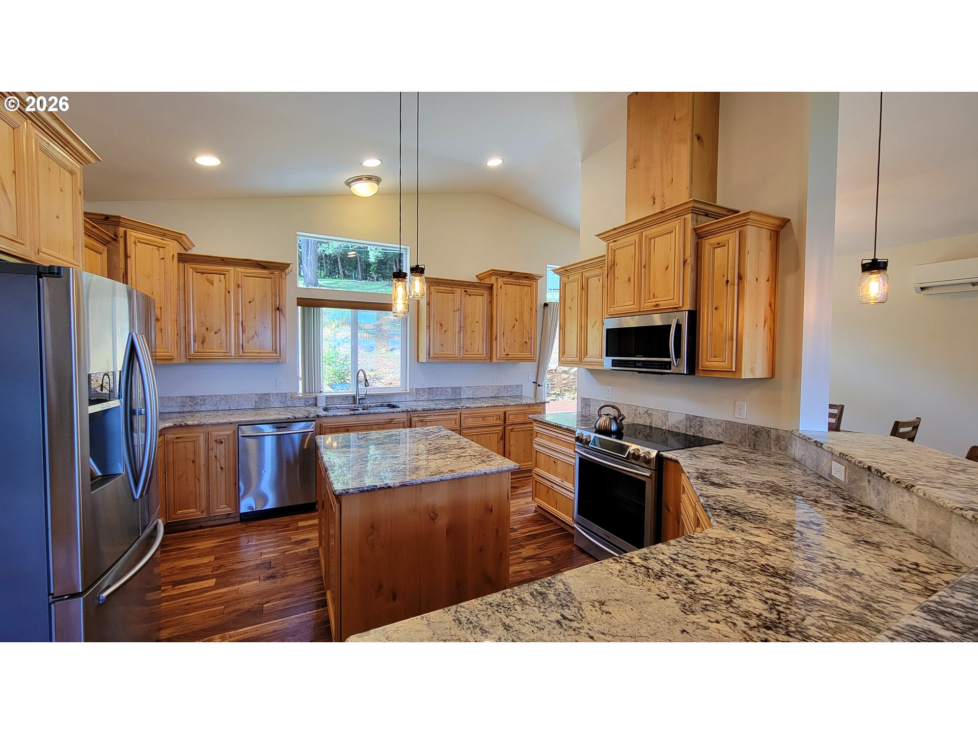 24674 Bolton Hill Road Veneta, OR 97487 - Photo 6 of 35 a kitchen with stainless steel appliances kitchen island granite countertop a sink refrigerator and microwave