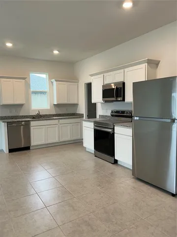 a kitchen with stainless steel appliances granite countertop a refrigerator sink and stove
