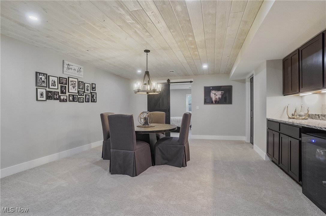4437 Beach Road Medina, OH 44256 - Photo 29 of 50 Carpeted dining area featuring wood ceiling, beverage cooler, a barn door, and bar area