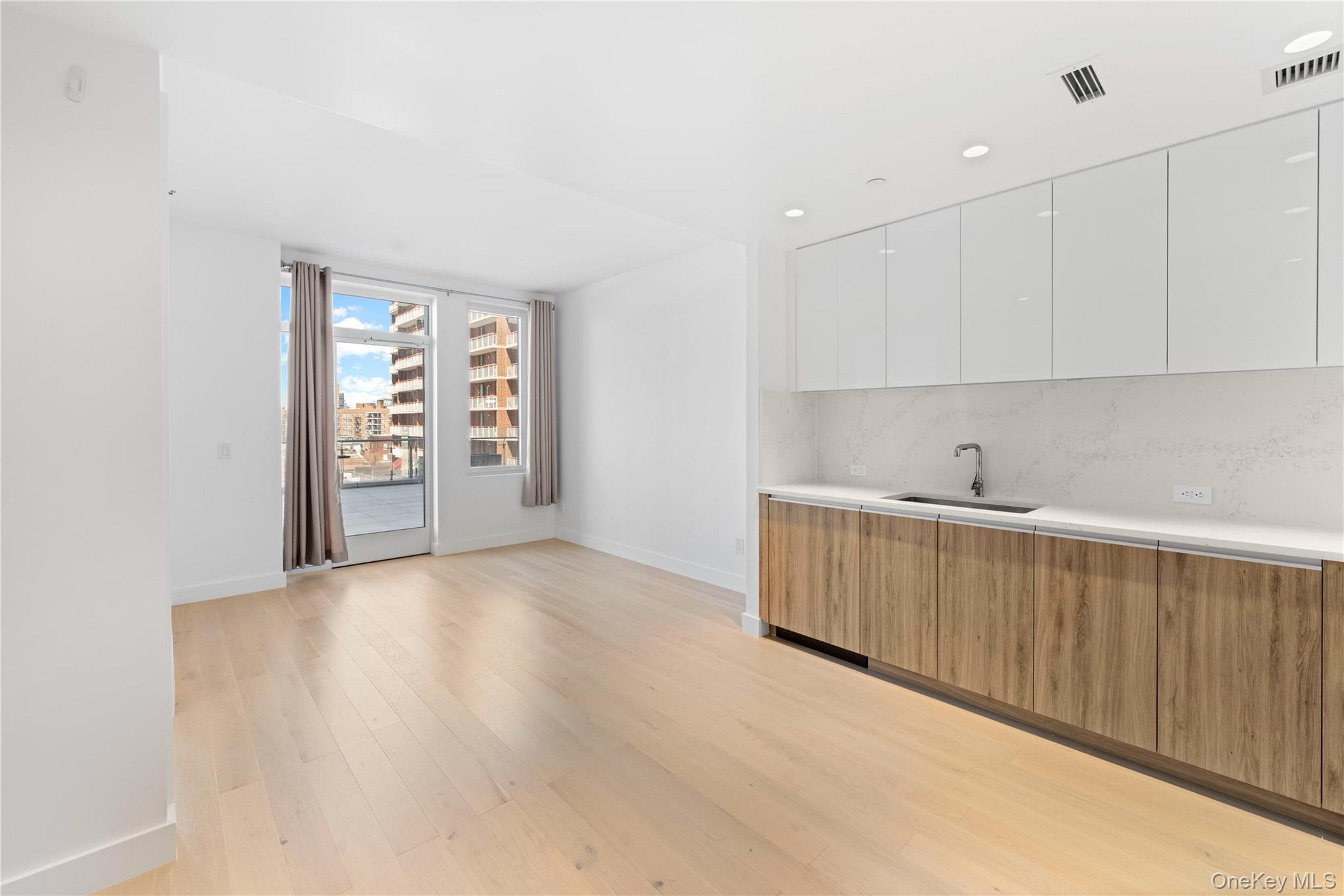 136-18 Maple Avenue, Unit 5G Queens, NY 11355 - Photo 3 of 35 a view of an empty room with wooden floor