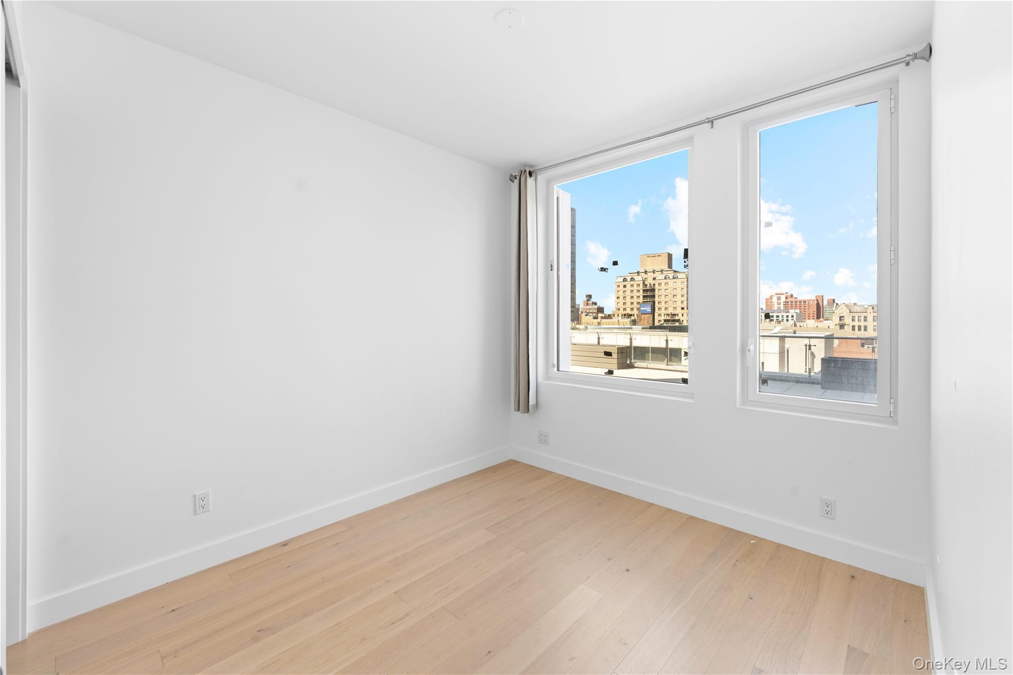 136-18 Maple Avenue, Unit 5G Queens, NY 11355 - Photo 5 of 35 a view of an empty room with a window