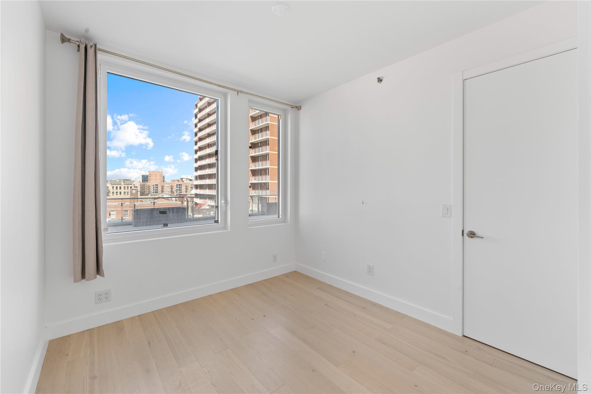 136-18 Maple Avenue, Unit 5G Queens, NY 11355 - Photo 7 of 35 a view of empty room with floor to ceiling window