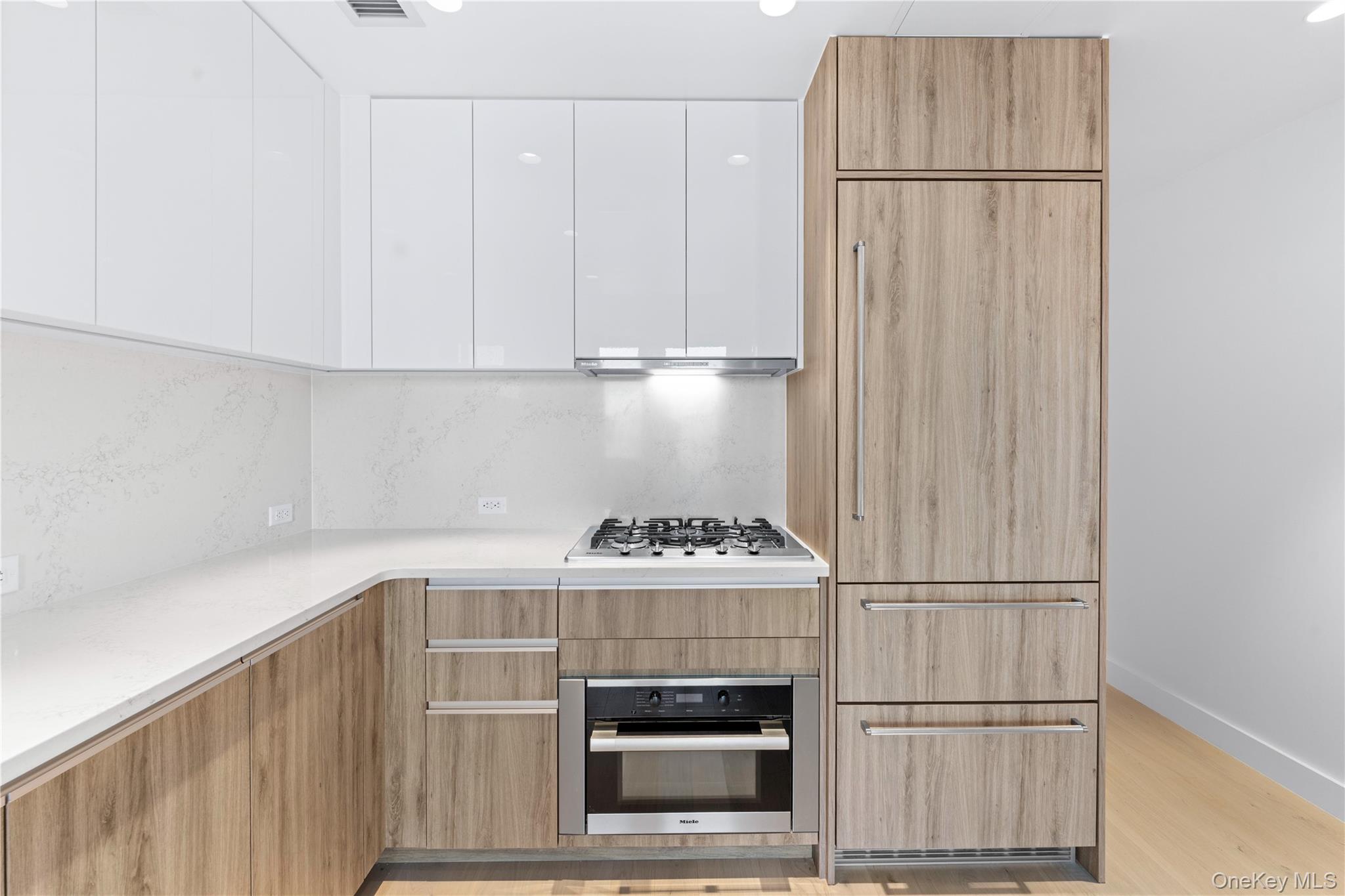 136-18 Maple Avenue, Unit 5G Queens, NY 11355 - Photo 9 of 35 a kitchen with a white cabinets and a stove