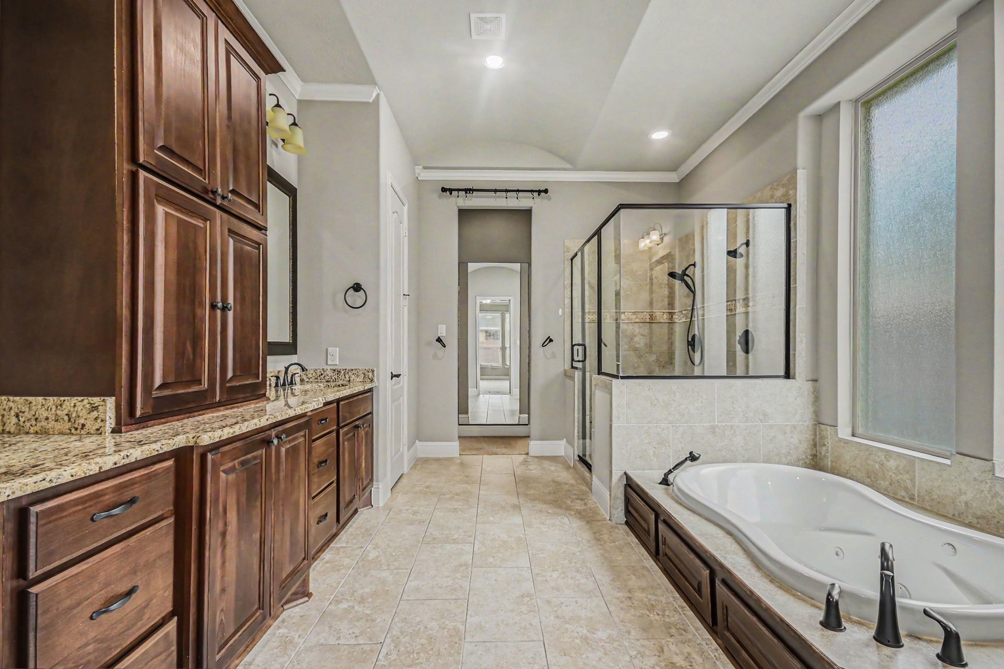 3310 Ralston Edge Lane Houston, TX 77059 - Photo 47 of 50 a spacious en suite bathroom with a granite countertop tub sink a mirror a bathtub and shower