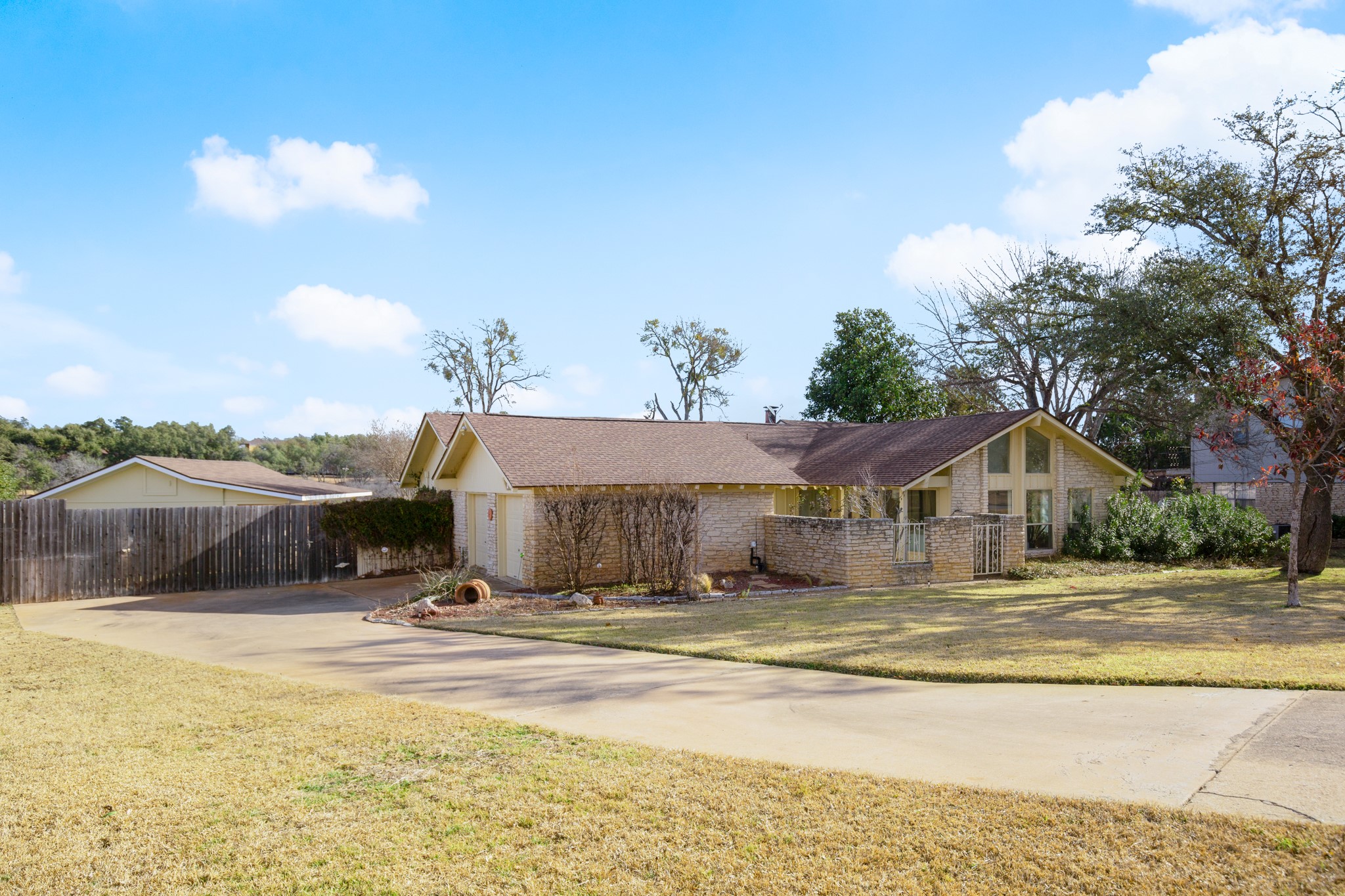 209 Ridgecrest Road Georgetown, TX 78628 - Photo 11 of 40 A long, gently sloping driveway leads down to a side-facing two car attached garage with space for additional driveway parking and a level area in front of the door.