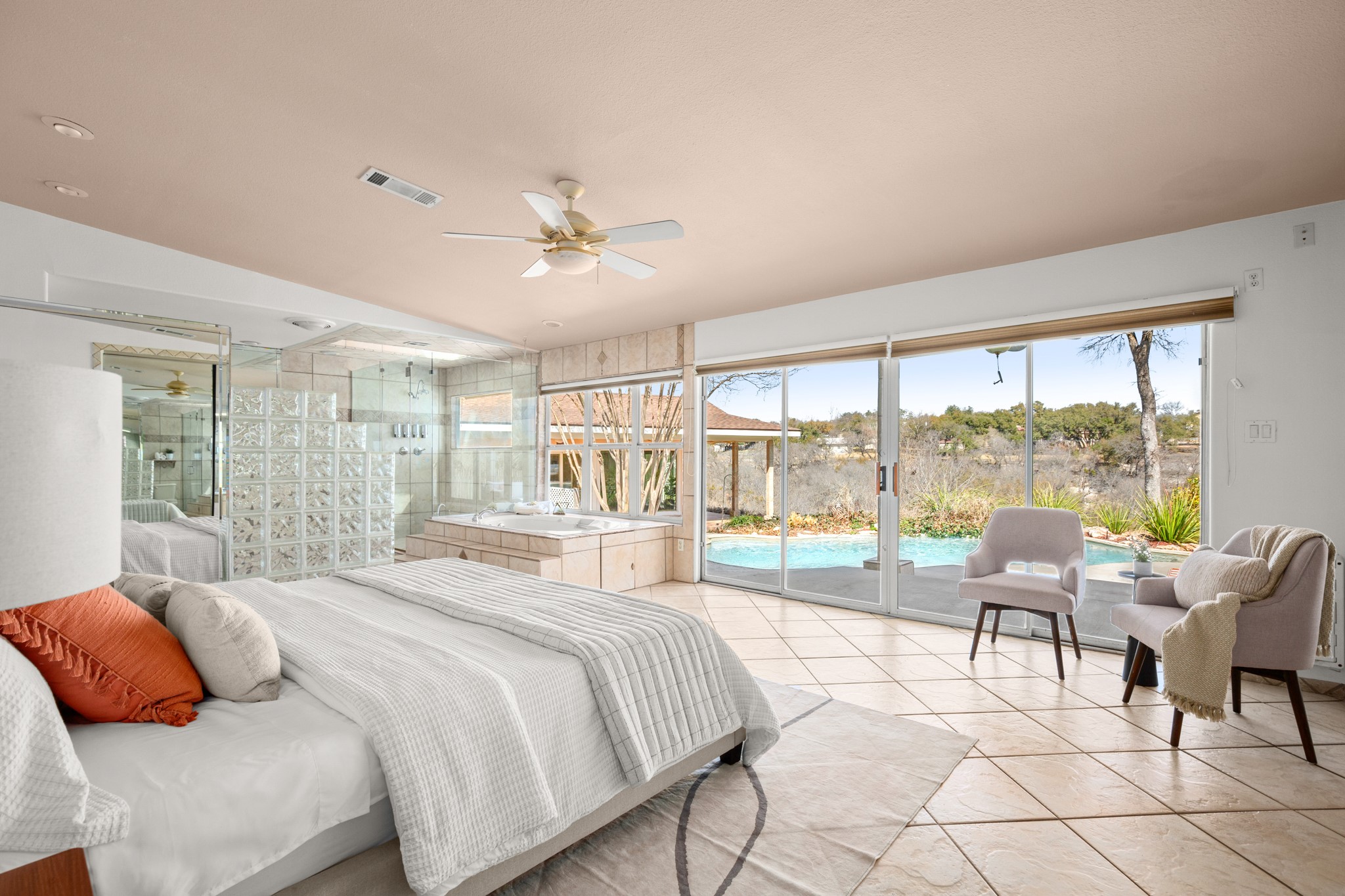 209 Ridgecrest Road Georgetown, TX 78628 - Photo 21 of 40 The primary suite is an amazing oversized retreat lined with four panel glass sliders that overlook the pool with long distance tree top views.