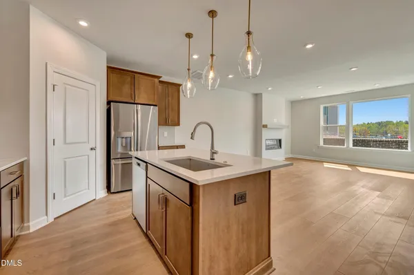 a kitchen with stainless steel appliances granite countertop a sink a refrigerator and a large window