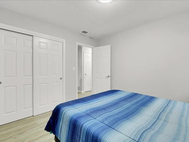 a bedroom with a bed and wooden floor