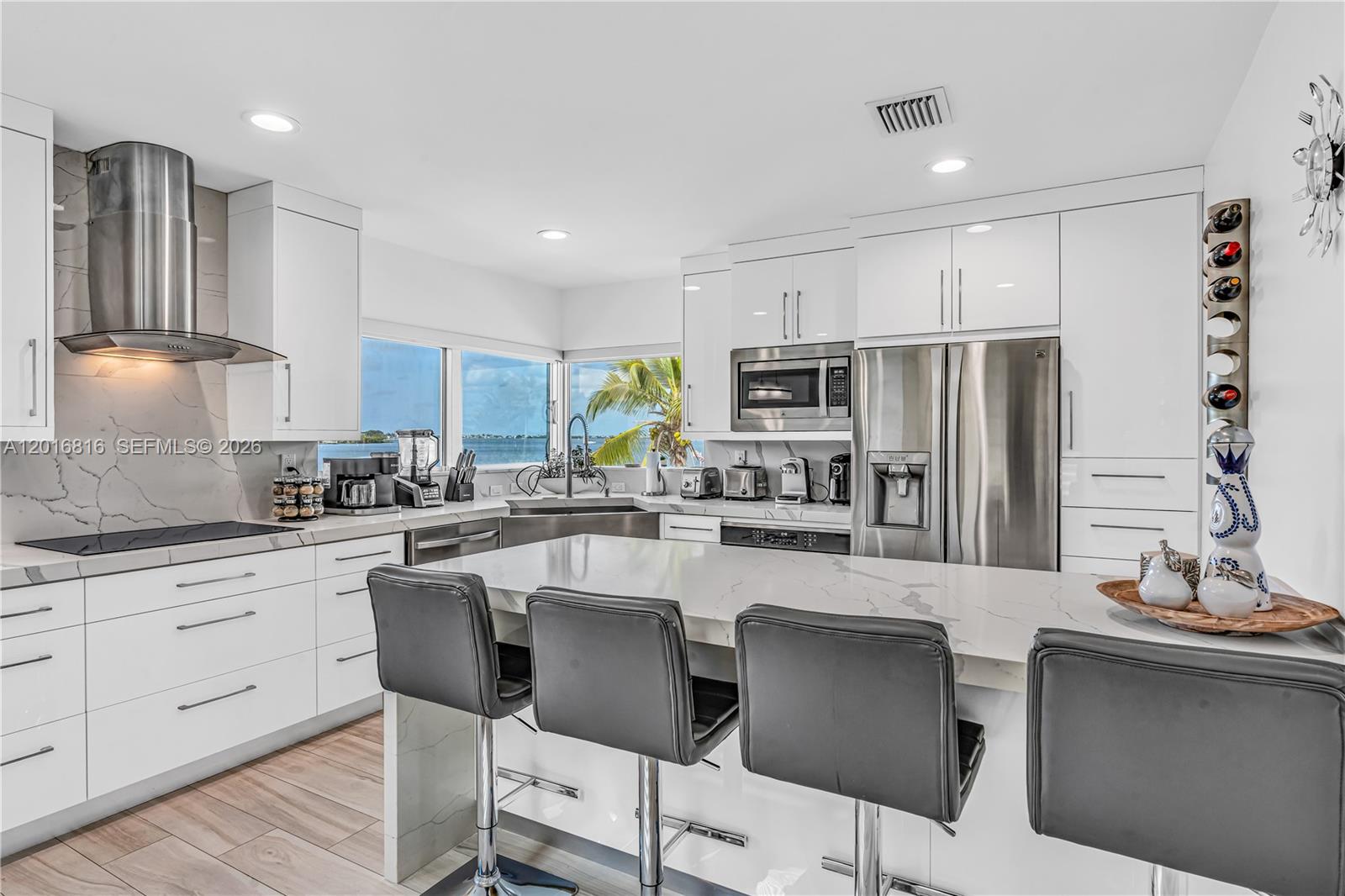 325 Calusa Key Largo, FL 33037 - Photo 3 of 32 a kitchen with stainless steel appliances granite countertop a stove a sink a refrigerator white cabinets and wooden floor