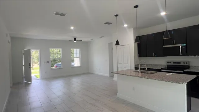 a view of a kitchen with a sink and a refrigerator