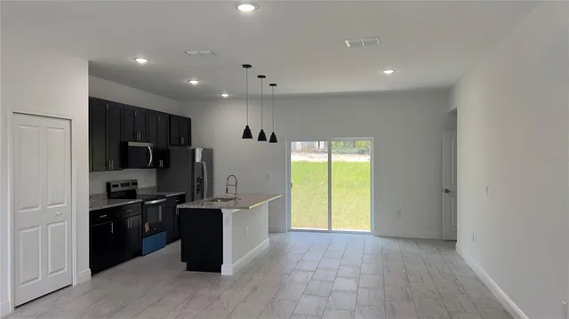 a kitchen with stainless steel appliances granite countertop a refrigerator and a sink