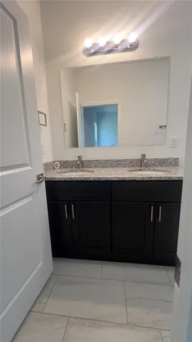 a bathroom with a granite countertop sink a toilet a mirror and shower