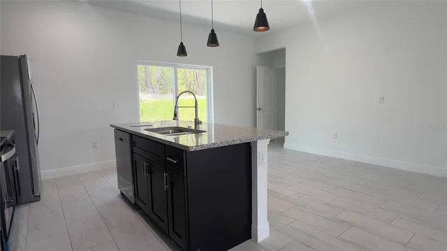 a kitchen with stainless steel appliances granite countertop a sink a stove and a refrigerator