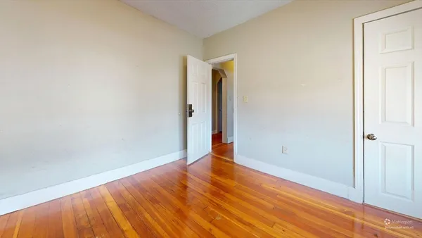 a view of an empty room with wooden floor