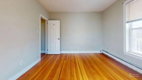 a view of a room with wooden floor and small window