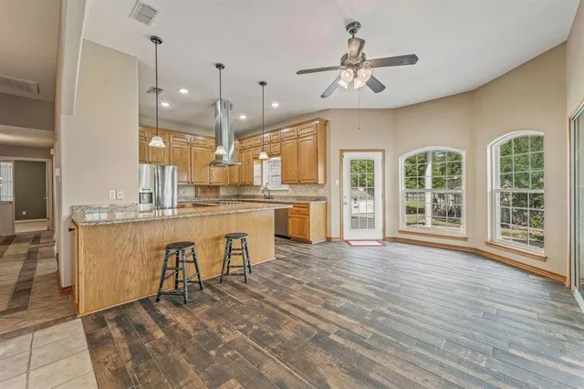 a view of a kitchen with granite countertop a stove top oven a sink and cabinets