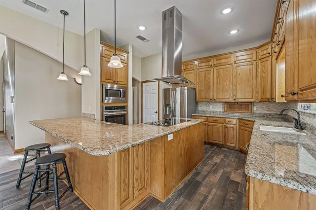 a kitchen with stainless steel appliances granite countertop a sink and a refrigerator