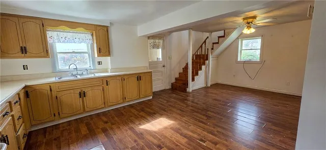 a view of a kitchen with wooden floor and electronic appliances