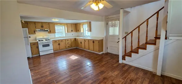 a kitchen with wooden floors and white appliances