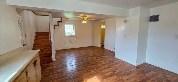 a view of a room with wooden floor and entryway