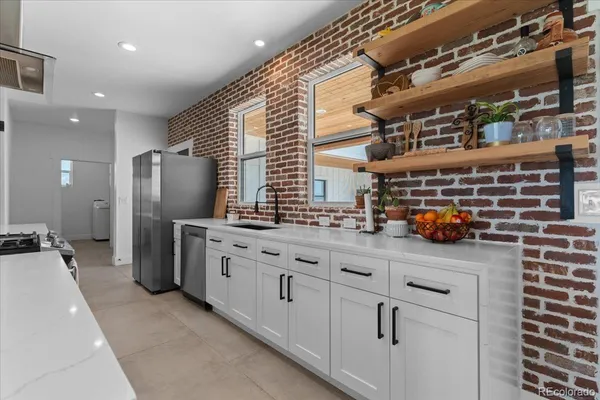 a kitchen with refrigerator and chairs