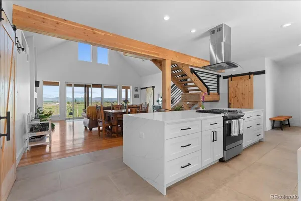 a living room with furniture a wooden floor and a large window