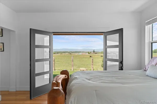 a bedroom with a bed and a large window