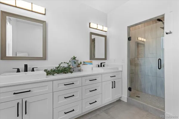 a bathroom with a double vanity sink mirror and shower