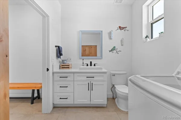 a spacious bathroom with a toilet sink and a mirror