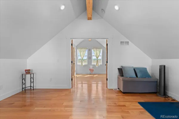 wooden floor in an empty room with a window and fireplace