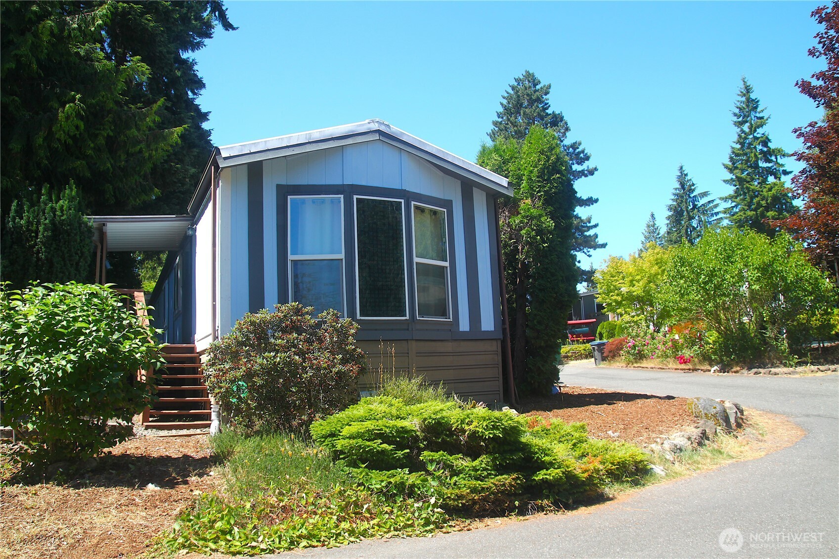 3060 Northeast McWilliams Road, Unit 9 Bremerton, WA 98311 - Photo 4 of 16 a view of a house with brick walls and a yard with plants