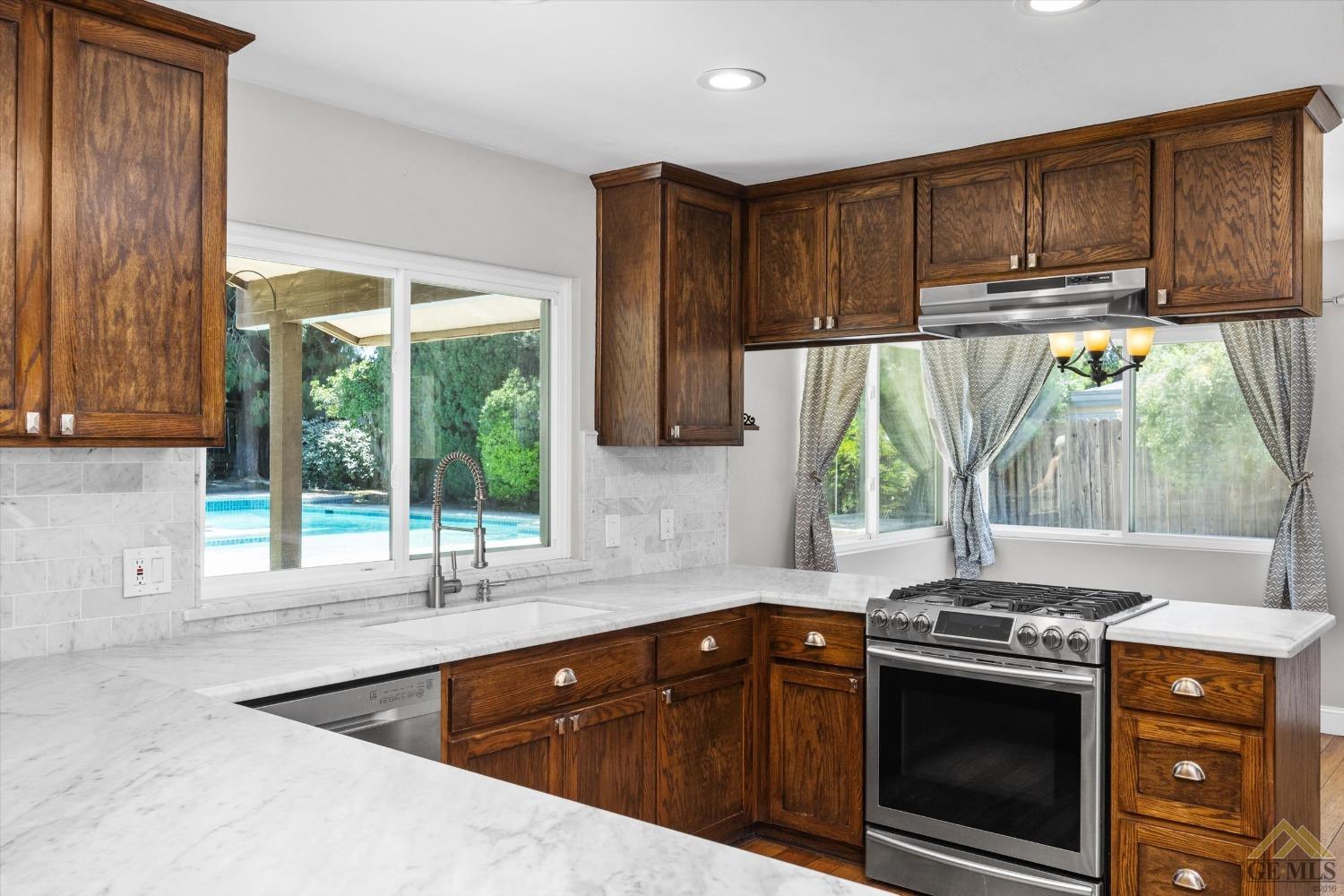 Undisclosed Address Bakersfield, CA 93308 - Photo 12 of 40 a kitchen with stainless steel appliances granite countertop a stove a sink and a microwave