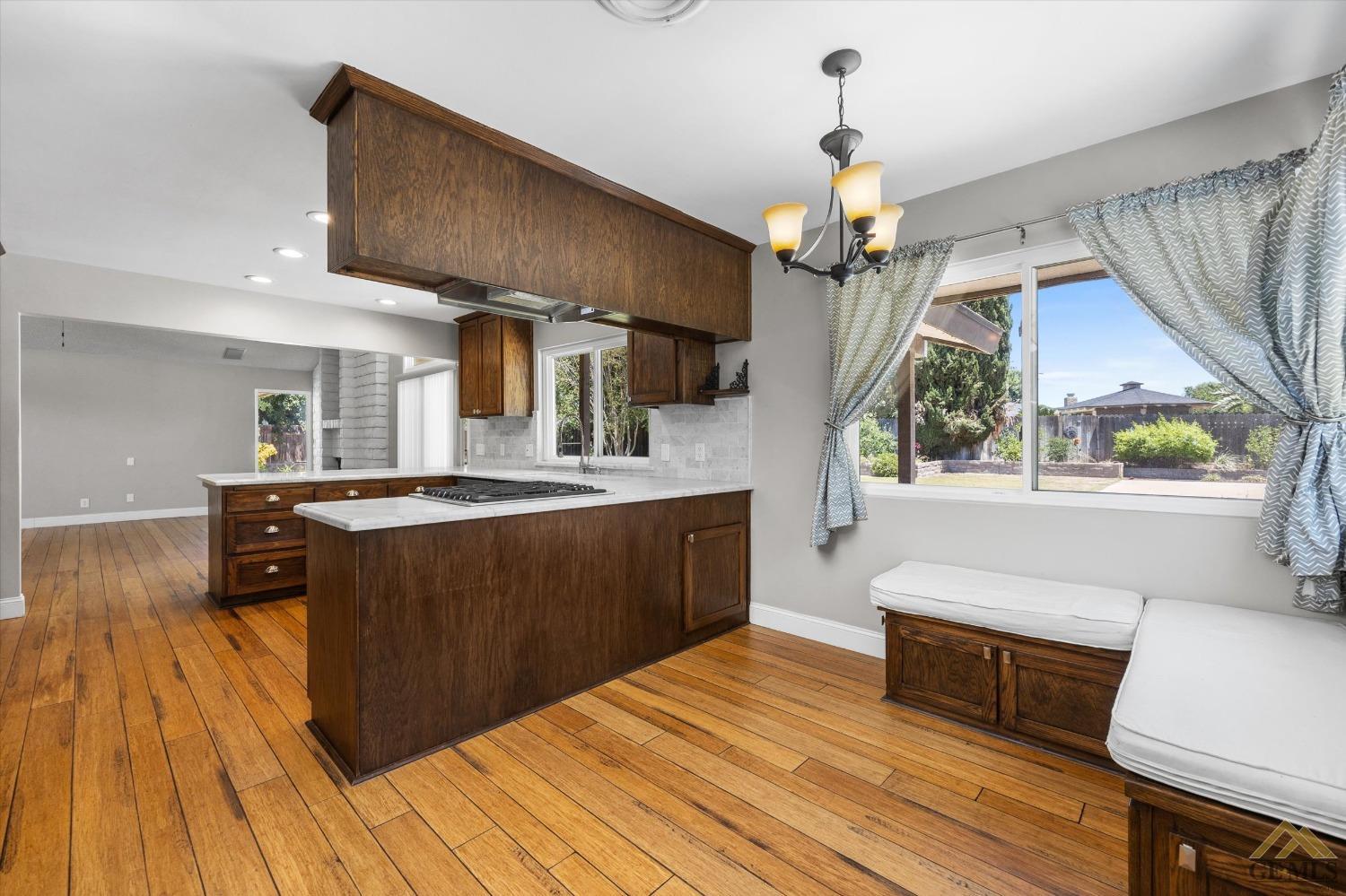 Undisclosed Address Bakersfield, CA 93308 - Photo 15 of 40 a kitchen with stainless steel appliances granite countertop a refrigerator a sink dishwasher a stove and a dining table with wooden floor