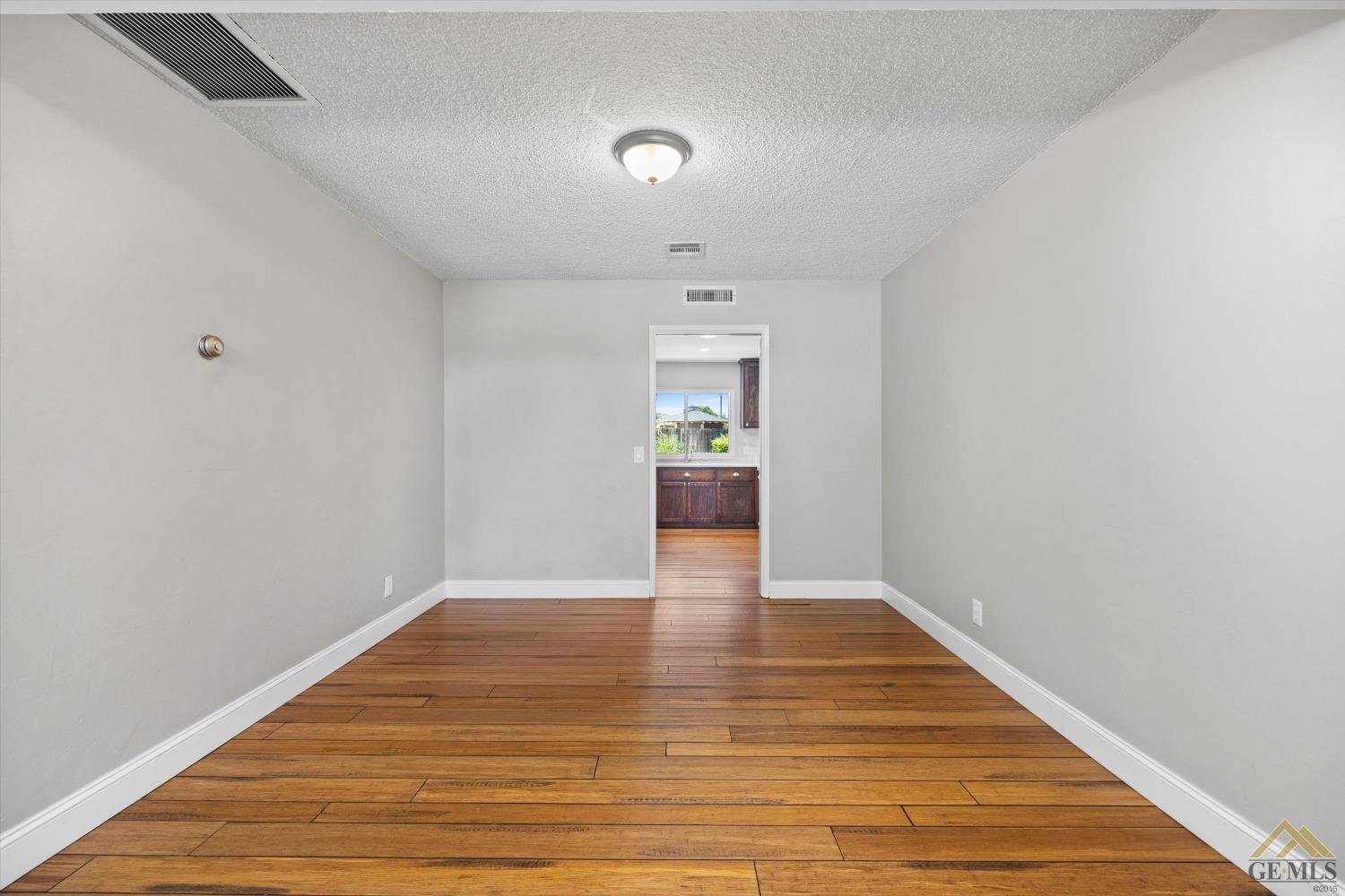 Undisclosed Address Bakersfield, CA 93308 - Photo 17 of 40 a view of an empty room with wooden floor and a window