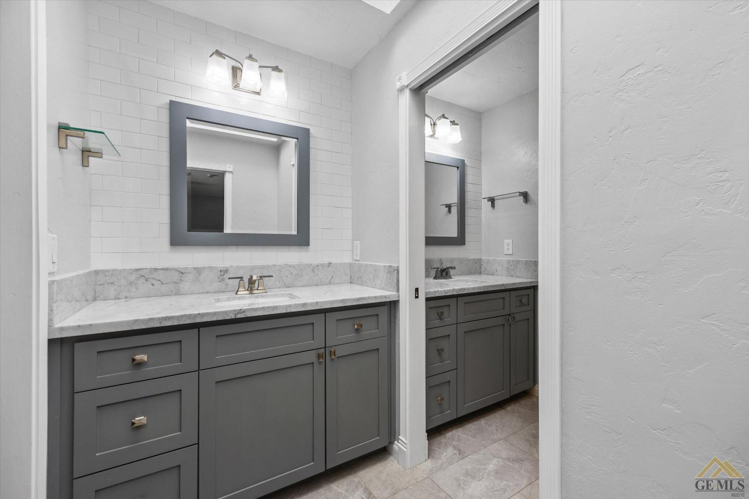 Undisclosed Address Bakersfield, CA 93308 - Photo 20 of 40 a bathroom with a granite countertop sink vanity and mirror