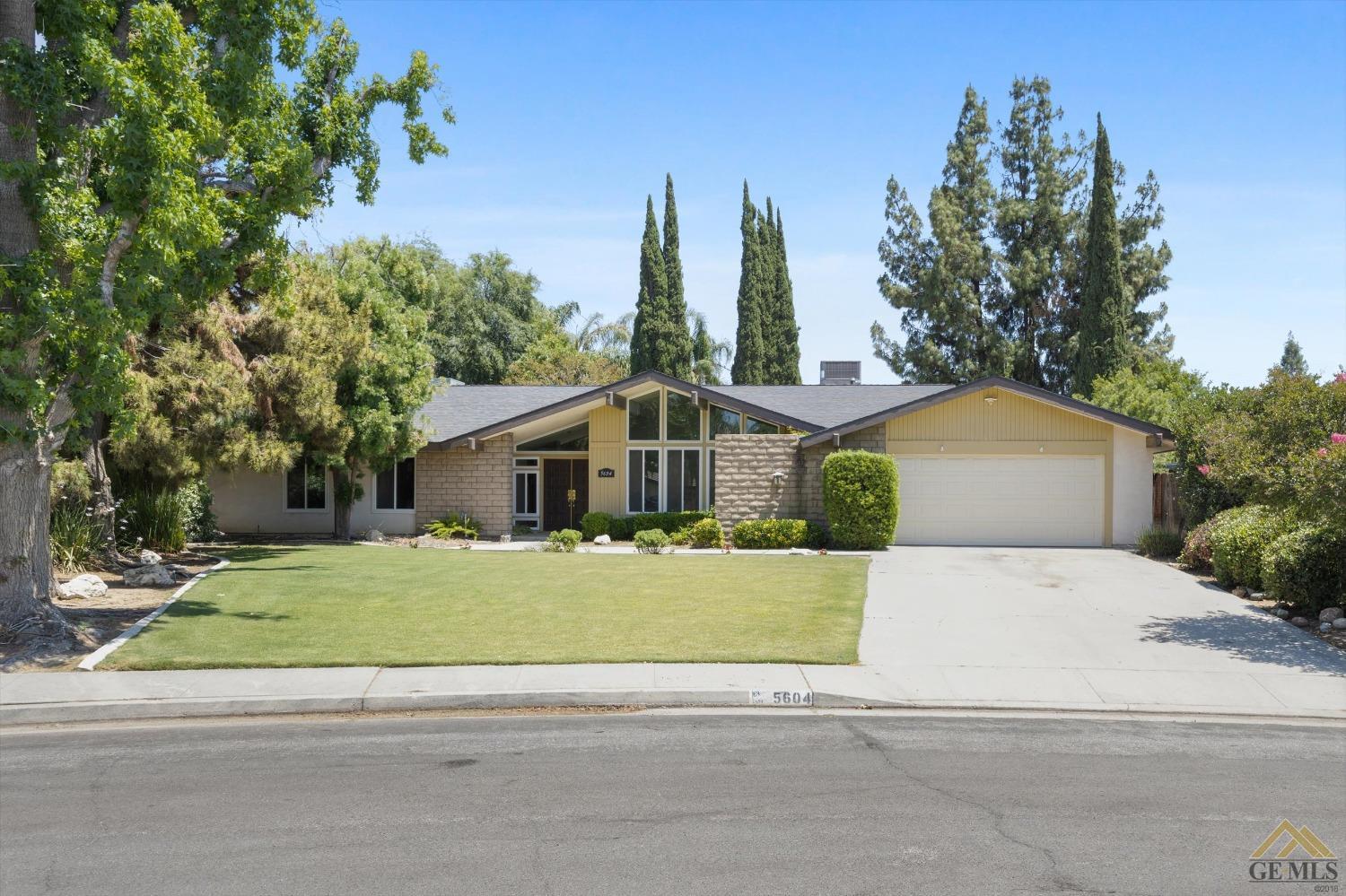 Undisclosed Address Bakersfield, CA 93308 - Photo 3 of 40 a front view of a house with a yard and trees